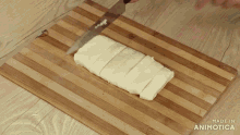 a person is cutting a piece of cheese on a wooden cutting board made in animatica
