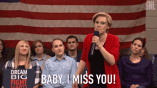 a woman holding a microphone says " baby i miss you " in front of a group of people