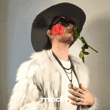 a man with a red rose in his mouth is wearing a white fur coat and a black hat