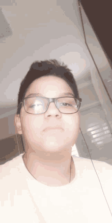 the boy is wearing glasses and a yellow shirt .