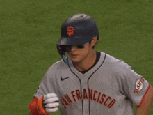 a baseball player wearing a san francisco jersey holds up his arm