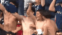 a shirtless man is being lifted in the air by a group of people wearing tel shirts