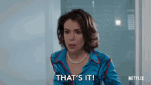 a woman in a blue shirt and pearls is saying that 's it
