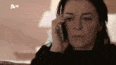 a woman is crying while talking on a cell phone with a hd logo in the corner