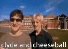 two men are standing next to each other in front of a building with the words clyde and cheeseball written below them .