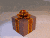 a brown gift box with a gold bow
