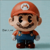 a close up of a mario figurine with a red hat and overalls
