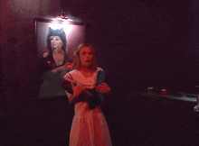 a woman is playing a video game in a dark room with a red light behind her