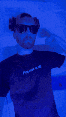 a man wearing sunglasses and a t-shirt that says " i 'm not a dj "