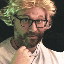 a man wearing glasses and a blonde wig is making a funny face