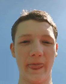 a young man 's face is shown with a blue sky in the background .