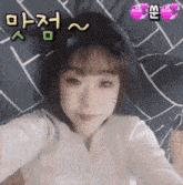 a girl wearing cat ears takes a selfie with korean writing on the bottom