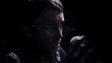 a man is speaking into a microphone in a dark room .