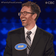 a man wearing a suit and tie has a name tag that says ryan