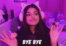 a girl wearing headphones and a cat ear headband says bye bye