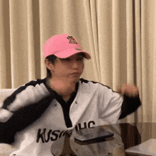 a man wearing a pink hat and a white shirt that says kush on it