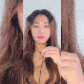a woman with long hair is wearing headphones and holding a cord .