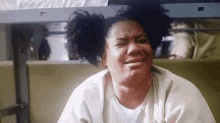 a woman with curly hair is sitting in a chair and making a face
