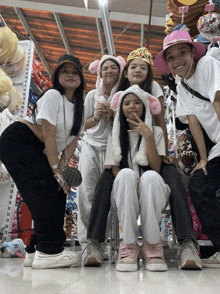 a group of girls wearing bunny ears hats pose for a picture