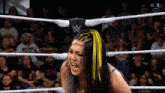 a woman in a wrestling ring with a w logo on her hat