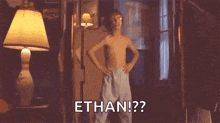 a shirtless boy is standing in a room with his hands on his hips and says ethan .
