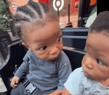 two babies are sitting next to each other in front of a target store