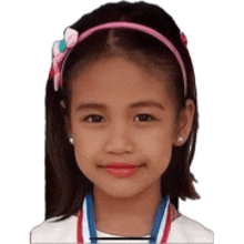 a little girl with a medal around her neck and a headband