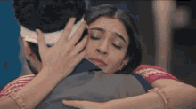 a man and a woman are hugging each other and the woman is touching the man 's face .