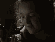a woman holding a gun in her hand in a dark room