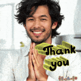 a man with his hands folded in front of a thank you sticker