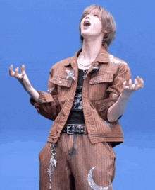 a man wearing a brown jacket and pants with a crescent moon on his pants