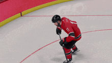a hockey player wearing a red jersey that says canes on it
