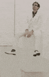 a man in a white suit is sitting on a white box