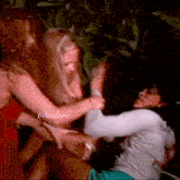 a woman in a red dress is fighting another woman in a white shirt with @adore written on the bottom