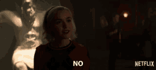 a woman is standing in front of a netflix ad