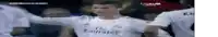 a soccer player wearing a fly emirates jersey stands in front of his teammates