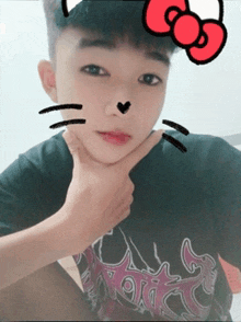 a boy wearing a black shirt with a hello kitty sticker on his face