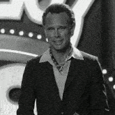 a man in a suit stands in front of a sign that says ' lucky ' on it