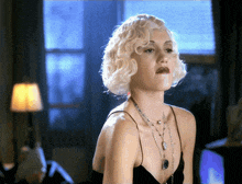 a woman with blonde hair is wearing a black tank top