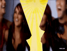 a group of people standing next to each other with a yellow light behind them and the words rbd.gif on the bottom