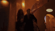 a man and a woman walking down stairs in a dark room
