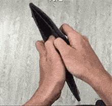 a person is holding an empty wallet with their hands .