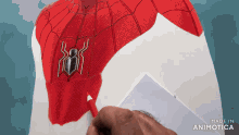 a person is drawing a spider on the back of a spiderman costume