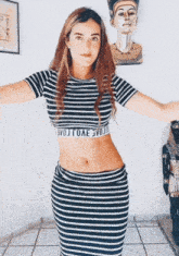 a woman wearing a black and white striped crop top that says evojioae evojio