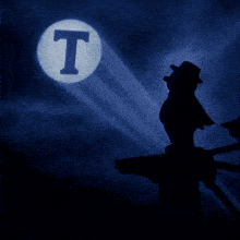 a silhouette of a man stands in front of a light that says t