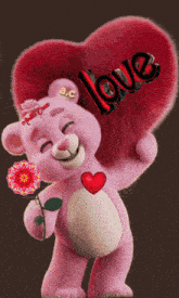 a pink teddy bear is holding a red heart with the word love written on it