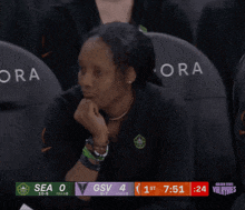a woman sits in a stadium watching a basketball game between the seahawks and the gsv