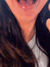 a close up of a woman 's face with her mouth open