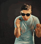 a young man wearing sunglasses and a chain around his neck
