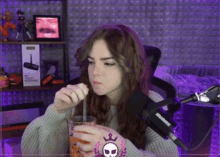 a woman is drinking through a straw in front of a microphone that says shure on it